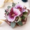 Soft pink orchids paired with delicate pearl accents and lush greenery create