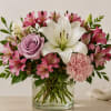 Pink and white bouquet with a lily and rose in a glass vase