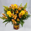 Yellow roses and orange alstroemeria in a mosaic glass vase.