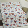 A cheerful quilted throw patterned with red, white and blue bows, flags