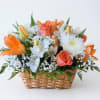 Basket arrangement of orange roses, white flowers, and lilies