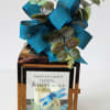 Memorial lantern with a blue ribbon bow and a candle inside