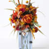 Autumn floral arrangement with orange blooms in a white lantern