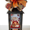 Fall lantern with an orange ribbon bow and autumn-themed insert