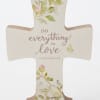 Decorative cross plaque with floral print and the words "do everything in love"