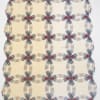 Cream quilt with a repeating oval chain pattern in muted red, blue, and gray
