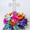 Floral arrangement with a clear cross topper and bright mixed blooms