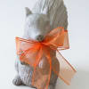 Gray squirrel figurine tied with an orange sheer ribbon
