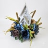 Blue floral arrangement with a white decorative church centerpiece