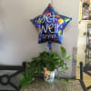 Potted green plant with a star-shaped balloon reading "get well soon"