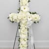 A serene cross composed entirely of white blooms offers a quiet, reverent