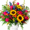 Two bold sunflowers anchor this large, celebratory flower arrangement, the kind of