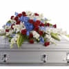 A broad, low casket spray that lays like a final embrace, its