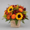 Autumn bouquet with sunflowers, orange roses, and mums in a wooden cube vase