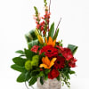 A compact wooden box overflowing with bold red roses, fiery orange lilies