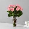 Soft pink roses gathered tall in a clear glass vase create a