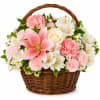 A hand-gathered round wicker basket overflowing with soft pinks, crisp whites and