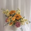 A cheery mix of yellow roses, sunflowers, pink carnations, and white daisies