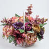 Basket arrangement of multicolored flowers in pink, purple, and peach tones