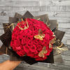 Large bouquet of red roses wrapped in black paper with gold accents