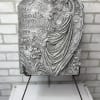 Gray memorial plaque with an angel and flowers on a stand