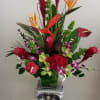 Tall tropical flower arrangement in a decorative pedestal vase