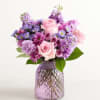 Pink and purple mixed bouquet in a textured glass vase