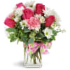 Pink roses and white daisies in a clear glass vase with a pink ribbon