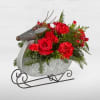 Red roses and carnations in a metal sleigh container