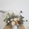 Loose bouquet of cream and blush roses in a white vase