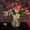 Tulip bouquet with pale cream flowers in a clear glass pitcher vase