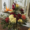 An elegant mixture of hydrangeas, red rose, curly willow, and a single