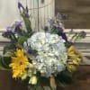 Mixed blue and yellow flowers, in glass cylinder vase.