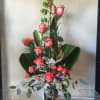 Tall floral arrangement with pink roses in a glass vase