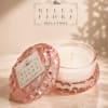 Pink glass candle jar with a white candle and matching lid