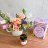 Pink and peach rose arrangement in a white mug with tea and honey gift items