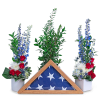 Red, white, and blue floral tribute with a folded flag in a wooden frame