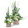 Two tall floral arrangements with white roses and green blooms in birch containers
