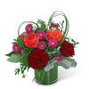 Bouquet of red and orange roses with purple daisies in a glass vase