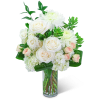 White roses and chrysanthemums in a clear glass vase with green foliage