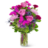 Pink roses and magenta flowers in a clear glass vase with purple butterflies
