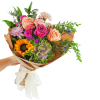 Hand-tied bouquet of mixed roses, carnations, and a sunflower in brown paper