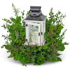 White lantern centerpiece surrounded by green foliage
