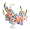 Peach roses and blue hydrangeas in a white vase with butterfly picks