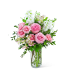 Pink roses and white flowers arranged in a clear glass vase