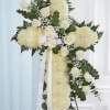 A large standing cross crafted from densely packed white chrysanthemums creates an