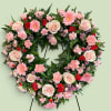 Heart-shaped floral wreath with pink roses, carnations, and daisies