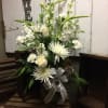 White floral arrangement with roses and daisies in a glass vase
