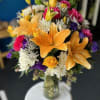 Colorful bouquet with lilies, roses, and chrysanthemums in a glass vase