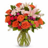 (ONE-SIDED) This arrangement features orange roses, carnations, alstroemeria, and lilies&mdash;perfect for any